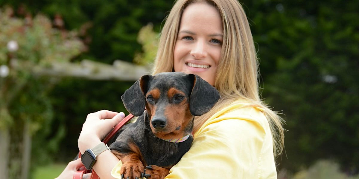 blond woman carrying small dog